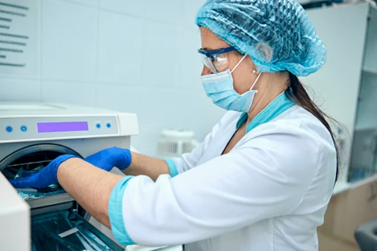 Technician operating advanced sterilization equipment in the surgery center's sterile processing department